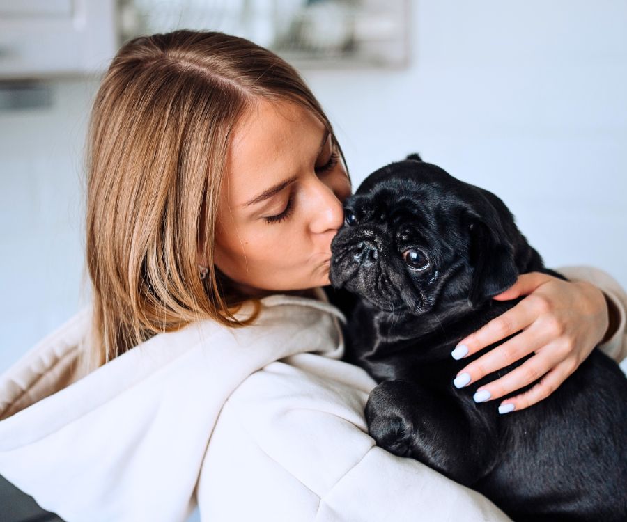 woman-kissing-a-black-pug-900x750-1